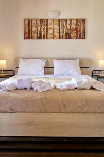 a large bed with two pillows on top of it at Omalia Village in Áno Khóra