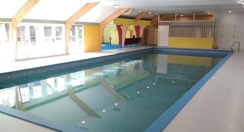 a swimming pool in a building with a large pool at Villa Pimpelmees - Sunclass 54 in Durbuy