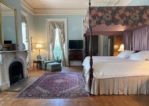 a bedroom with a canopy bed and a fireplace at John Rutledge House Inn in Charleston