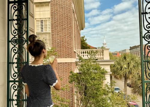 a woman looking out of a gate at a building at John Rutledge House Inn in Charleston