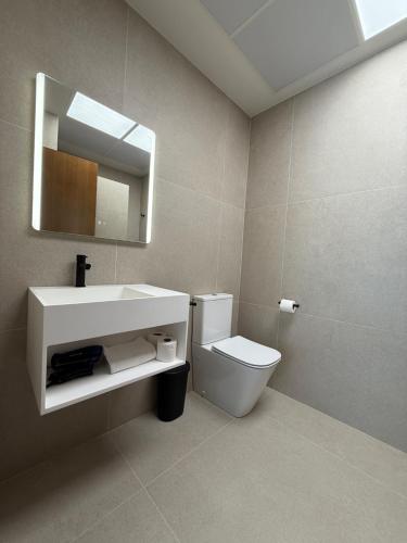 a bathroom with a sink and a toilet and a mirror at Villa Raquel Montanejos in Montanejos
