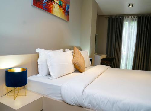 a bedroom with a bed with white sheets and pillows at Accra Luxury Apartments @ Pearl in Accra