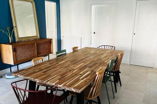 une table en bois avec des chaises et un miroir dans l'établissement Very spacious cocoon with garden near the sea, au Pouliguen