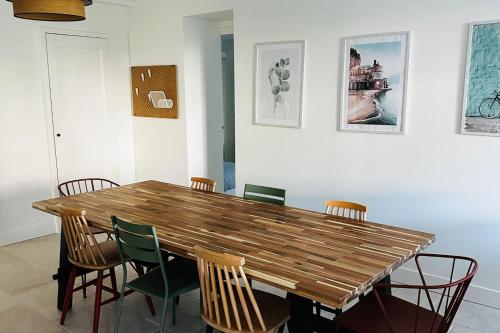 - une table et des chaises en bois dans l'établissement Very spacious cocoon with garden near the sea, au Pouliguen