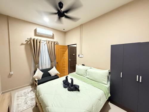 a bedroom with a bed and a ceiling fan at Rumah No 5 in Taiping