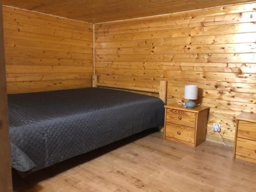 a bedroom with a bed and a wooden wall at Schwarzenberský panský dvůr in Čimelice