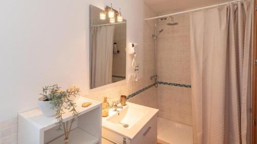 un bagno con lavandino, specchio e doccia di Los cortinales a Setenil
