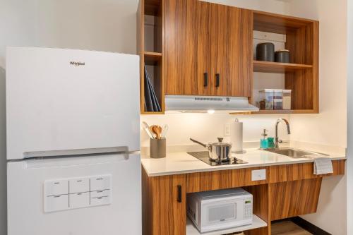 a kitchen with a refrigerator and a microwave at Uptown Suites Extended Stay Tampa FL - Riverview in Riverview