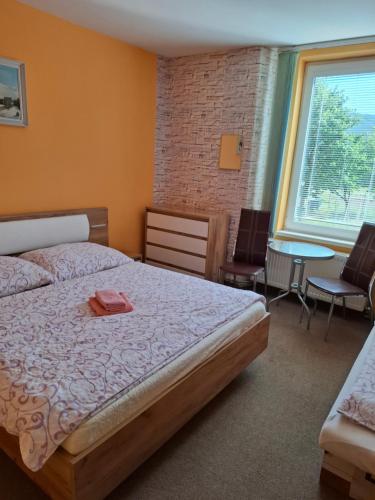 a bedroom with a bed and a table and chairs at Privát Čujová in Hrabušice