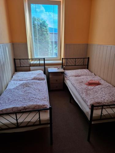 two beds in a room with a window at Privát Čujová in Hrabušice