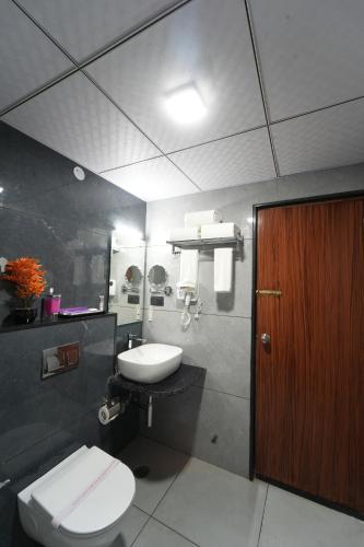 a bathroom with a white toilet and a sink at VOVO Boutique Hotel in Bengaluru