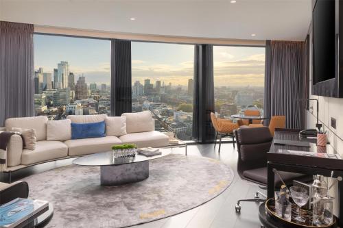 a living room with a white couch and a large window at art'otel London Hoxton in London