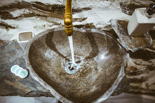 a bathroom sink with water coming out of it at Ellafos Traditional Living in Elafonisi