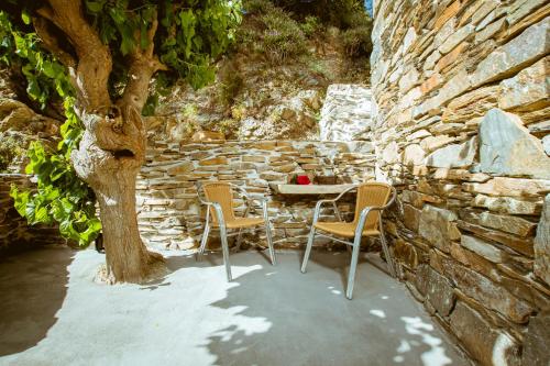 a table and chairs sitting next to a stone wall at Ellafos Traditional Living in Elafonisi