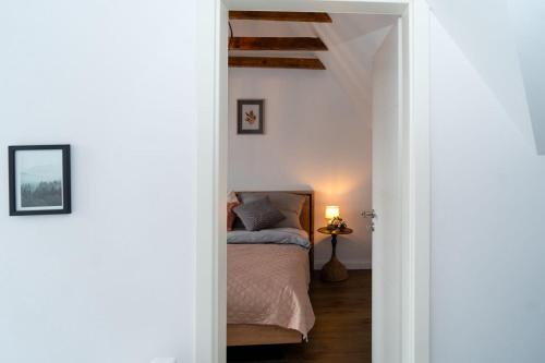 a bedroom with a bed in a white room at Dat Krautacker Huus in Rönnau