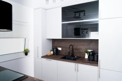 a kitchen with white cabinets and a sink at Dat Krautacker Huus in Rönnau