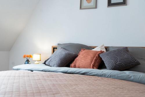 a bed with a bunch of pillows on it at Dat Krautacker Huus in Rönnau