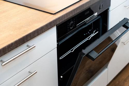 a black dishwasher in a kitchen next to a counter at Dat Krautacker Huus in Rönnau