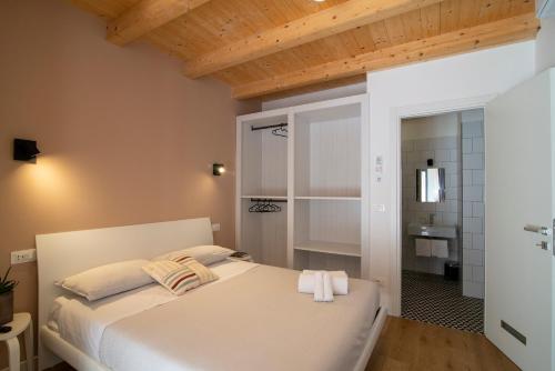a bedroom with a white bed with towels on it at ALOE Comfort Rooms in Pescara