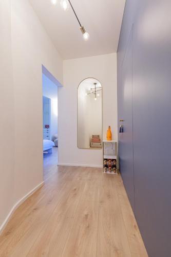a white room with a mirror and a wooden floor at City Mini Studio in Bratislava