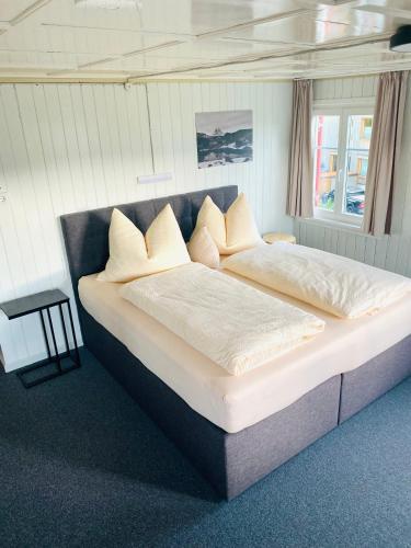 a large bed with white sheets and pillows at Gasthof goldener Adler Riefensberg in Riefensberg