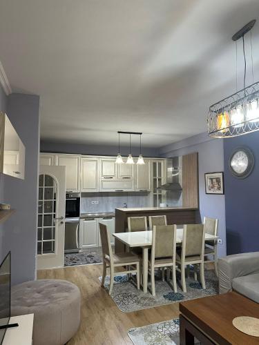 una cucina e un soggiorno con tavolo e sedie di Modern 2BR Apartment with Living Room and Private garage a Kashari