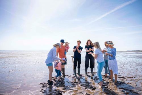 a group of people standing on the beach at TUI BLUE Sylt in Rantum