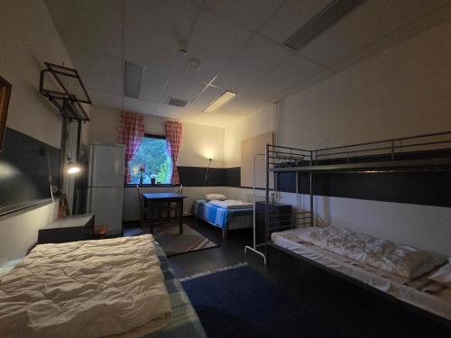a bedroom with two bunk beds and a table at Svenshögens vandrarhem in Svenshögen