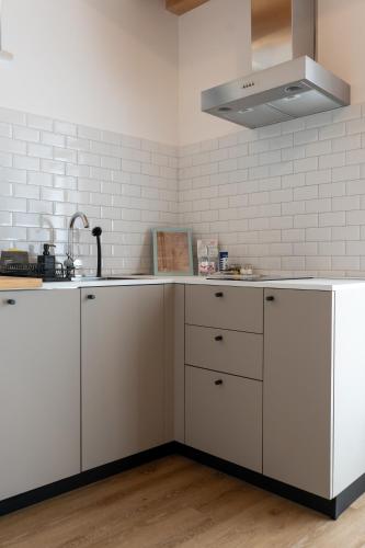 a kitchen with white cabinets and a sink at ALOE Comfort Rooms in Pescara