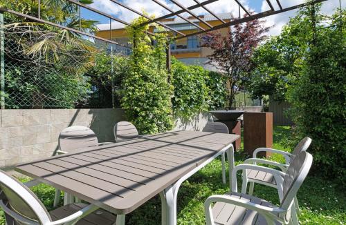 a picnic table and chairs in a garden at PEONIA 2 posti Wi-Fi AC free park Jacuzzi in Porlezza