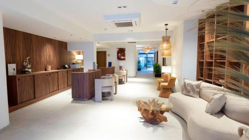 a living room with a white couch and chairs at Hotel Indigo Gandia Beach by IHG in Gandía