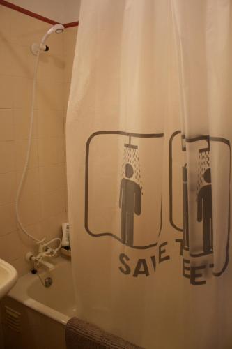 a bathroom with a shower curtain that says save me at Our sweet flat by the beach in Viana do Castelo