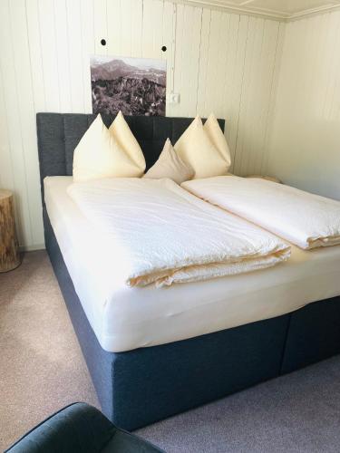 a large bed with white sheets and pillows at Gasthof goldener Adler Riefensberg in Riefensberg