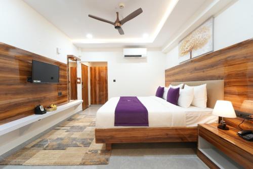 a bedroom with a bed and a flat screen tv at VOVO Boutique Hotel in Bengaluru