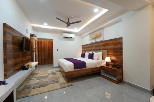 a bedroom with a king sized bed and a television at VOVO Boutique Hotel in Bengaluru