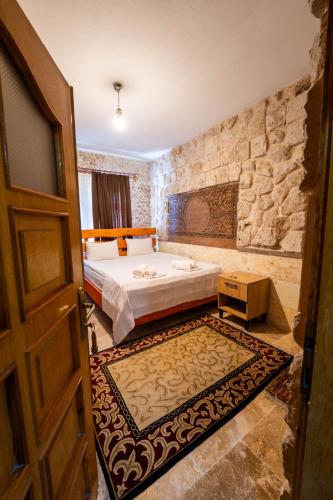a bedroom with a bed and a stone wall at hotels crazy horse in Ortahisar