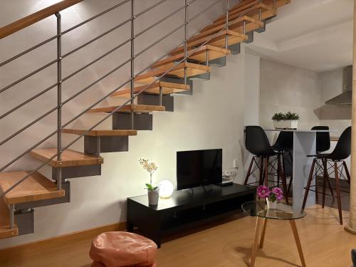 a living room with a staircase and a tv at Loft Almagro in Almagro