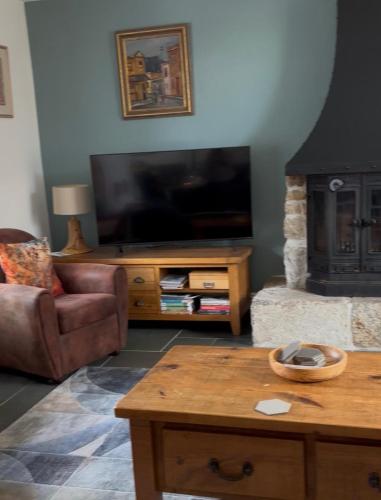 a living room with a tv and a couch and a table at Moorview Retreat, Dartmoor in Widecombe in the Moor