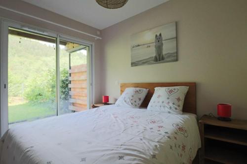 a bedroom with a white bed with a window at A4 - Résidence La Montille in Mont-Dore