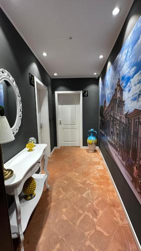 a hallway with a white table and a mirror at Miralong House in Catania
