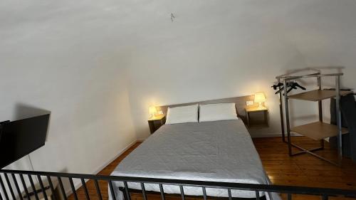 a small bed in a room with two lamps at Miralong House in Catania