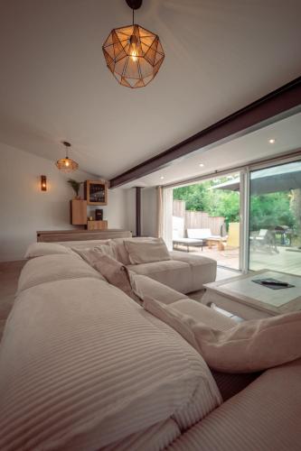 un salon avec un canapé et une grande fenêtre dans l'établissement Maison vu Lac en première ligne du lac de Lacanau avec terrain de tennis privatif, à Lacanau