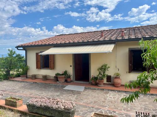 a house with a porch with potted plants at Nibbio III - Entire house in the heart of Chianti in Lucardo