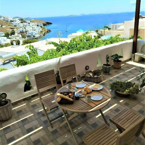 a table on a balcony with a view of the ocean at Primrose Apartments in Astypalaia Town