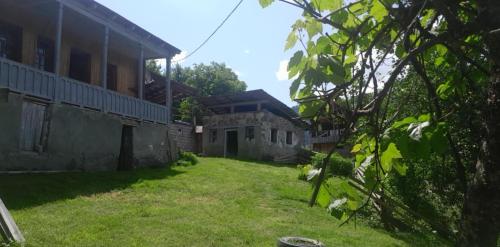 an outside view of a house with a yard at Sarag Mountain & Family Guesthouse Svaneti in Mestia