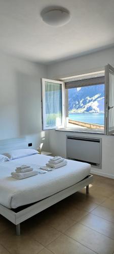 a bedroom with a bed with a view of the ocean at Lake Como View - Casa La Rosa in Abbadia Lariana