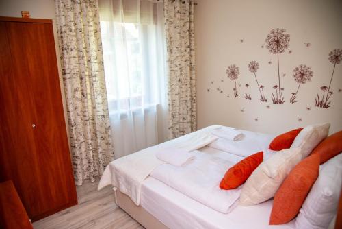 a bedroom with a bed with white sheets and orange pillows at Apartamenty Every Sky Polna 4 Karpacz in Karpacz