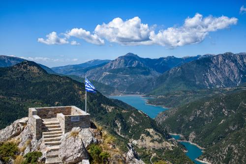 a flag on top of a mountain overlooking a lake at Omalia Village in Áno Khóra