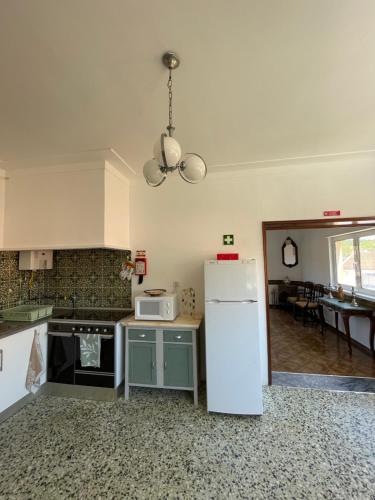 a kitchen with a white refrigerator and a microwave at Casa Valverde in Monsanto