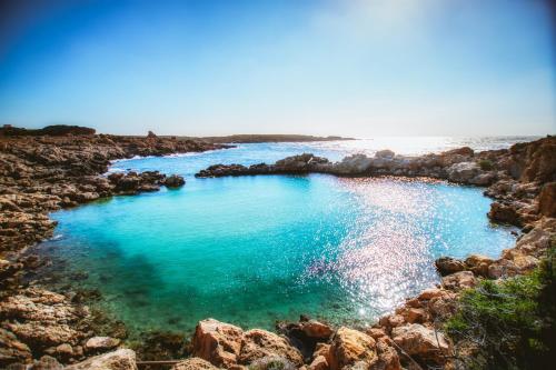 a large pool of water on a rocky beach at Ellafos Traditional Living in Elafonisi